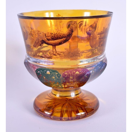 19 - AN UNUSUAL 19TH CENTURY BOHEMIAN AMBER GLASS CUP painted with fowl and motifs. 10 cm x 8 cm.