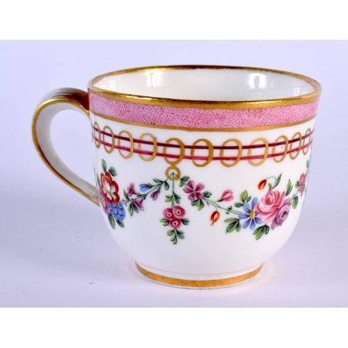 202 - Sevres coffee cup and saucer painted with festoons of flowers hanging from gilt rings under a pink b... 