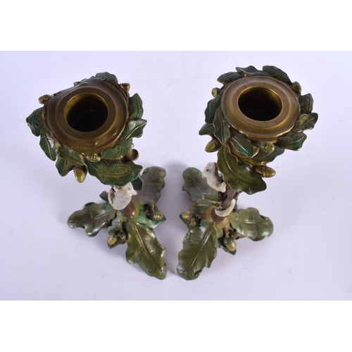 409 - A PAIR OF CONTINENTAL COLD PAINTED BRONZE CANDLESTICKS formed with squirrels climbing on a tree. 29 ... 