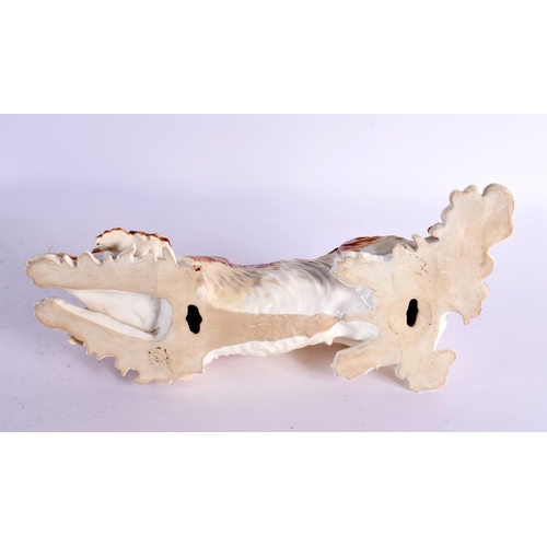 41 - A LARGE 19TH CENTURY CONTINENTAL PORCELAIN FIGURE OF A RECUMBENT DOG possibly Russian. 36 cm long.