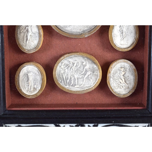 419 - A 19TH CENTURY FRAMED SET OF COUNTRY HOUSE PLASTER INTAGLIOS contained within an Italian ebonised fr... 