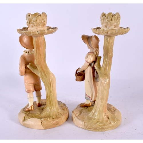 505 - A PAIR OF 19TH CENTURY ROYAL WORCESTER BLUSH IVORY CANDLESTICKS formed as figures. 20 cm high.