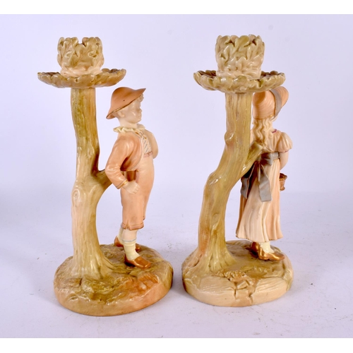 505 - A PAIR OF 19TH CENTURY ROYAL WORCESTER BLUSH IVORY CANDLESTICKS formed as figures. 20 cm high.