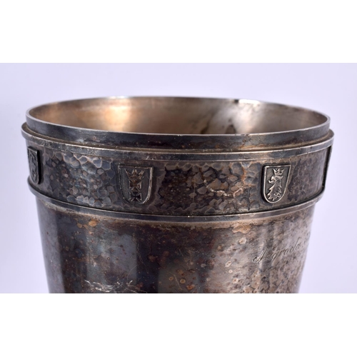 507 - A STYLISH ART NOUVEAU HAMMERED PEWTER ARMORIAL VASE bearing inscription to top. 38 cm x 10 cm.