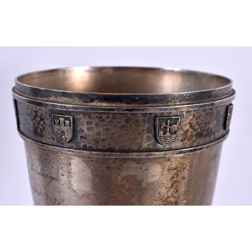 507 - A STYLISH ART NOUVEAU HAMMERED PEWTER ARMORIAL VASE bearing inscription to top. 38 cm x 10 cm.