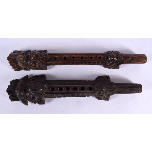 521 - AN UNUSUAL PAIR OF 19TH CENTURY ASIAN CAMBODIAN BURMESE CARVED WOOD PIPES modelled with Buddhistic f... 