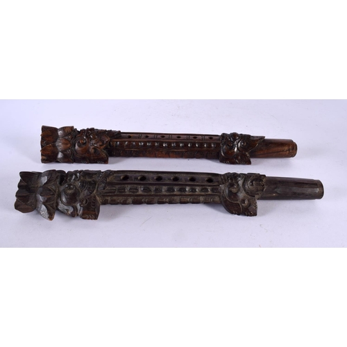 521 - AN UNUSUAL PAIR OF 19TH CENTURY ASIAN CAMBODIAN BURMESE CARVED WOOD PIPES modelled with Buddhistic f... 