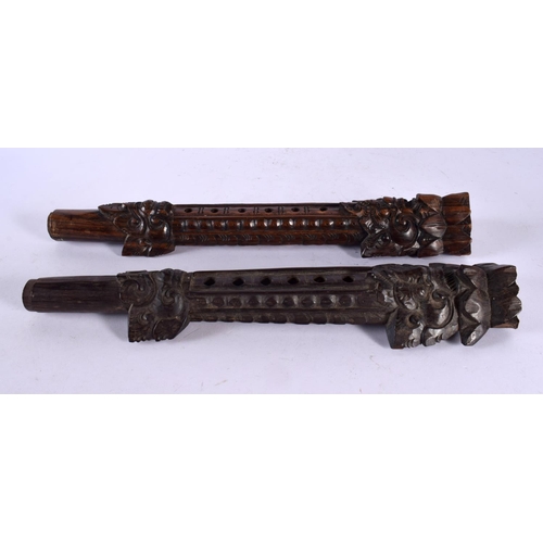 521 - AN UNUSUAL PAIR OF 19TH CENTURY ASIAN CAMBODIAN BURMESE CARVED WOOD PIPES modelled with Buddhistic f... 