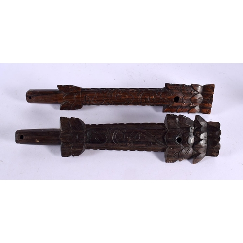 521 - AN UNUSUAL PAIR OF 19TH CENTURY ASIAN CAMBODIAN BURMESE CARVED WOOD PIPES modelled with Buddhistic f... 