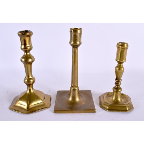 560 - THREE GEORGE III BRASS CANDLESTICKS. Largest 20 cm high. (2)