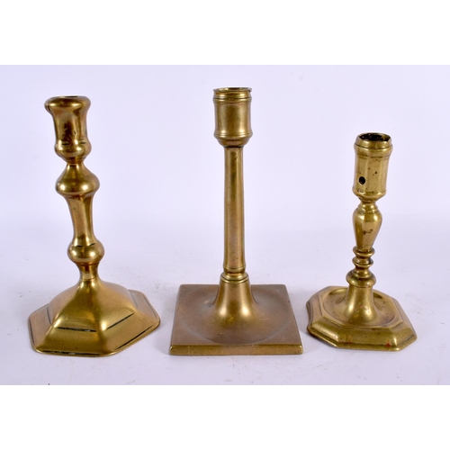 560 - THREE GEORGE III BRASS CANDLESTICKS. Largest 20 cm high. (2)