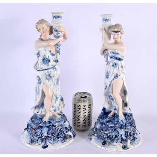 567 - A LARGE PAIR OF LATE 19TH CENTURY GERMAN PORCELAIN CANDLESTICKS formed as figures holding aloft scon... 