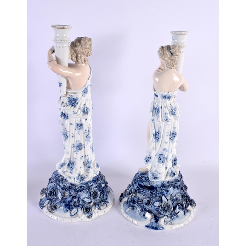 567 - A LARGE PAIR OF LATE 19TH CENTURY GERMAN PORCELAIN CANDLESTICKS formed as figures holding aloft scon... 