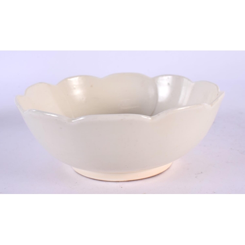 570 - A CHINESE QING DYNASTY DING STYLE CREAM GLAZED BOWL elegantly modelled with a lotus type flower inte... 