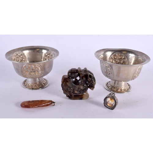 681 - A PAIR OF 19TH CENTURY CHINESE TIBETAN SILVER BOWLS together with an amber fish pendant etc. Silver ... 