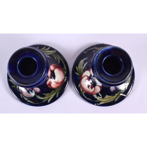 72 - A SMALL PAIR OF MOORCROFT CANDLESTICKS. 9 cm x 9 cm.