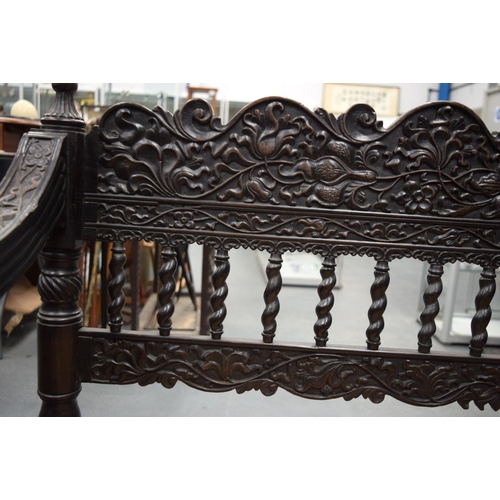 752 - A FINE EARLY 19TH CENTURY ANGLO INDIAN CARVED HARDWOOD SETTEE decorated with foliage and extensive v... 