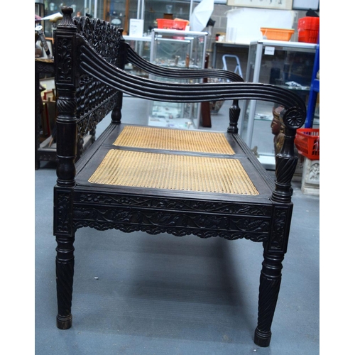 752 - A FINE EARLY 19TH CENTURY ANGLO INDIAN CARVED HARDWOOD SETTEE decorated with foliage and extensive v... 