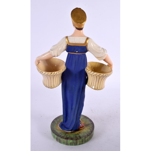 134 - A 19TH CENTURY RUSSIAN PORCELAIN FIGURE OF A FEMALE modelled holding two baskets. 24 cm x 12 cm.