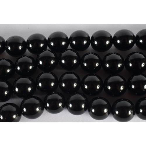 311 - A TURKISH MIDDLE EASTERN BLACK AMBER TYPE NECKLACE. 270 grams. 146 cm long, each bead 1.75 cm wide.