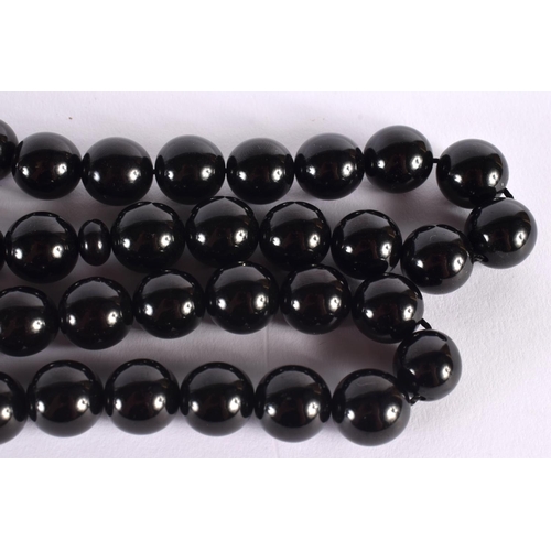 311 - A TURKISH MIDDLE EASTERN BLACK AMBER TYPE NECKLACE. 270 grams. 146 cm long, each bead 1.75 cm wide.