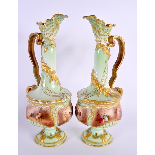 35 - A PAIR OF ANTIQUE FRENCH LIMOGES PORCELAIN EWER painted with figures in a landscape upon a green gro... 