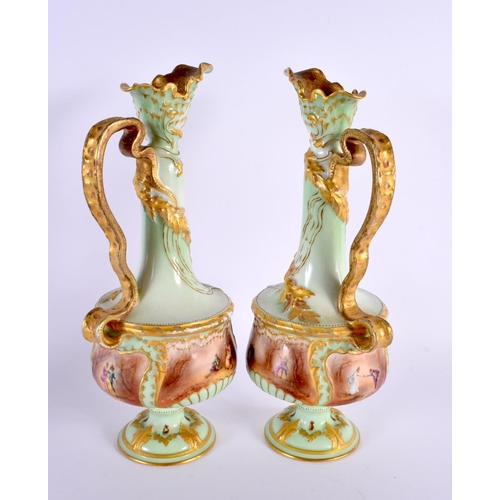 35 - A PAIR OF ANTIQUE FRENCH LIMOGES PORCELAIN EWER painted with figures in a landscape upon a green gro... 