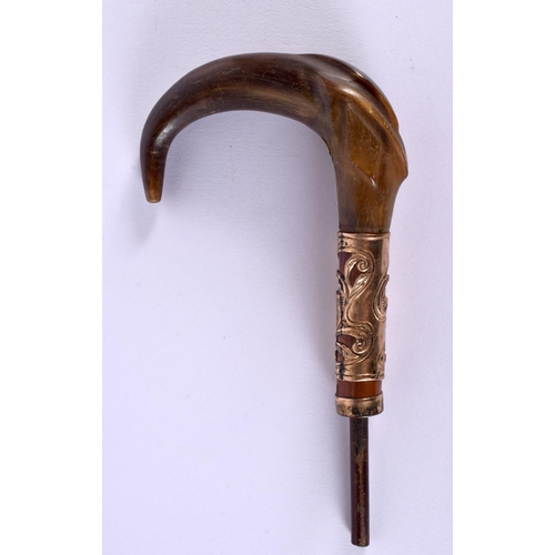 353 - AN ANTIQUE CARVED RHINOCEROS HORN CANE HANDLE with yellow metal mounts. 20 cm x 10 cm.