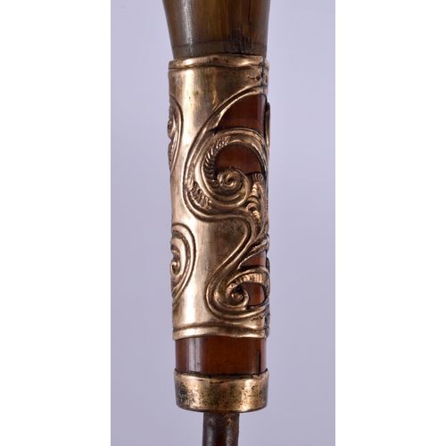 353 - AN ANTIQUE CARVED RHINOCEROS HORN CANE HANDLE with yellow metal mounts. 20 cm x 10 cm.