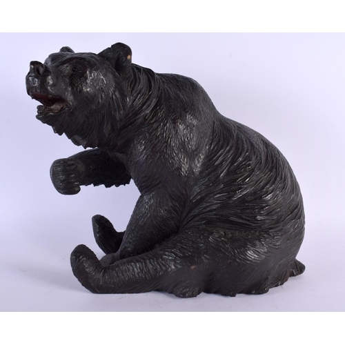 383 - A 19TH CENTURY BAVARIAN BLACK FOREST FIGURE OF A BEAR modelled seated with arm raised. 30 cm x 24 cm... 