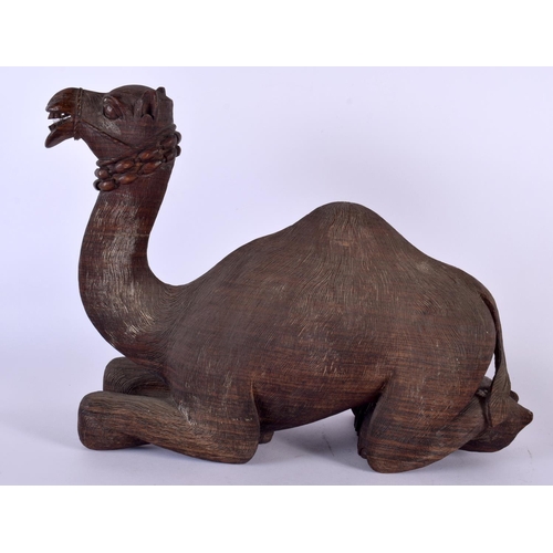 384 - A LARGE 19TH CENTURY ANGLO INDIAN CARVED HARDWOOD FIGURE OF A CAMEL modelled recumbent. 34 cm x 27 c... 