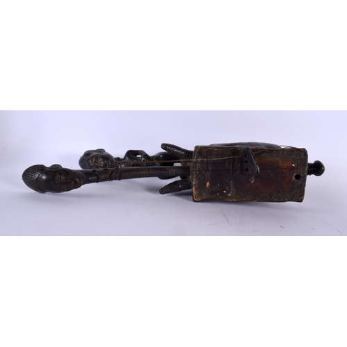 385 - A RARE AFRICAN TRIBAL CARVED WOOD INSTRUMENT formed with figures and mask heads. 43 cm long.