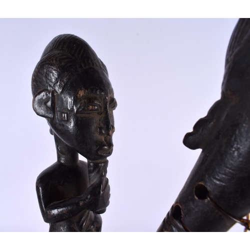 385 - A RARE AFRICAN TRIBAL CARVED WOOD INSTRUMENT formed with figures and mask heads. 43 cm long.