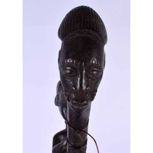 385 - A RARE AFRICAN TRIBAL CARVED WOOD INSTRUMENT formed with figures and mask heads. 43 cm long.