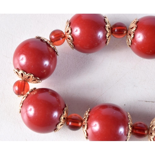 1031 - A CHERRY AMBER TYPE RED BEAD BRACELET. 26 grams. 5.25 cm wide.