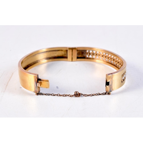 1166 - A VICTORIAN 15CT GOLD AND SEED PEARL BANGLE. 14.9 grams. 5.5 cm x 4.5 cm.