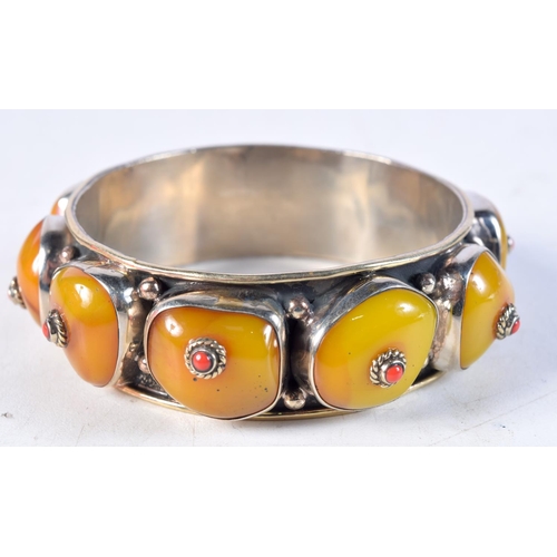 1227 - A SILVER AND AMBER BANGLE. 82 grams. 6.5 cm wide.