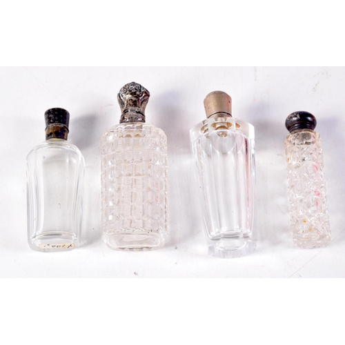 1265 - FOUR ANTIQUE SILVER TOPPED SCENT BOTTLES. Largest 9 cm x 3 cm. (4)