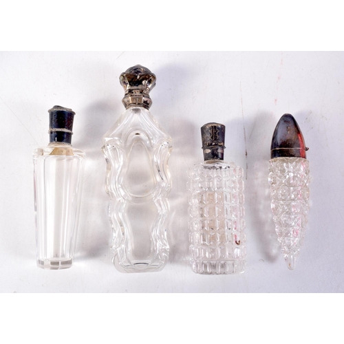 1266 - FOUR ANTIQUE SILVER TOPPED SCENT BOTTLES. Largest 12 cm x 3 cm. (4)