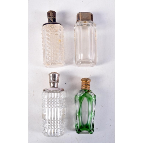 1285 - FOUR ANTIQUE SILVER TOPPED SCENT BOTTLES. Largest 12 cm x 3 cm. (4)