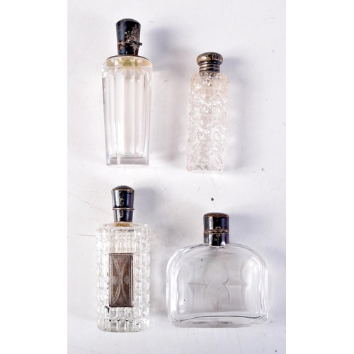 1288 - FOUR ANTIQUE SILVER TOPPED SCENT BOTTLES. Largest 12 cm x 3 cm. (4)