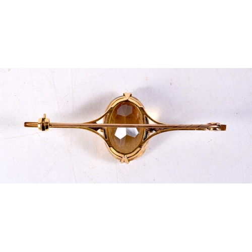 1291 - A 9CT GOLD YELLOW STONE BROOCH. 7.7 grams. 6.25 cm wide.