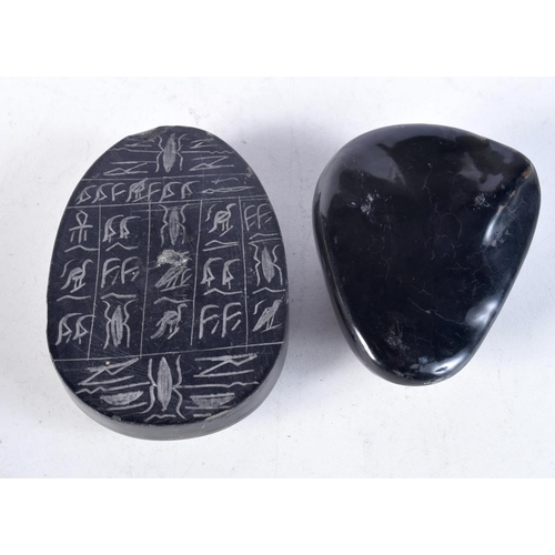 1684 - AN EGYPTIAN REVIVAL CARVED STONE PEBBLE together with another. Largest 10 cm x 7 cm. (2)