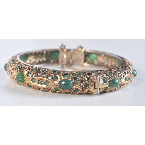 1745 - A CONTINENTAL YELLOW METAL EMERALD BRACELET. 38.4 grams. 6 cm wide.