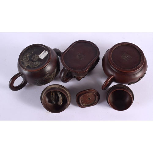 2069 - FIVE CHINESE YIXING POTTERY TEAPOT AND COVERS. Largest 15 cm wide. (5)