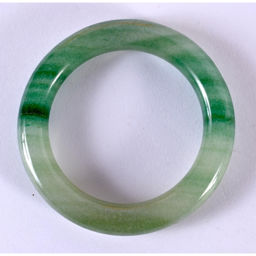 2167 - A CHINESE CARVED JADEITE BANGLE 20th Century. 8 cm diameter.