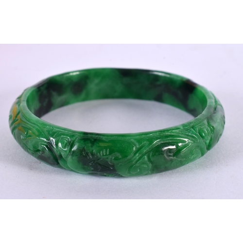 2168 - A CHINESE CARVED JADEITE BANGLE 20th Century. 7 cm diameter.