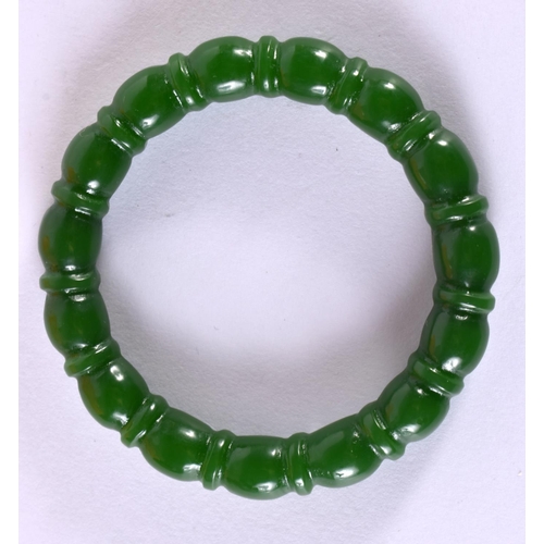 2185 - A CHINESE CARVED GREEN JADE BANGLE 20th Century. 7.5 cm diameter.