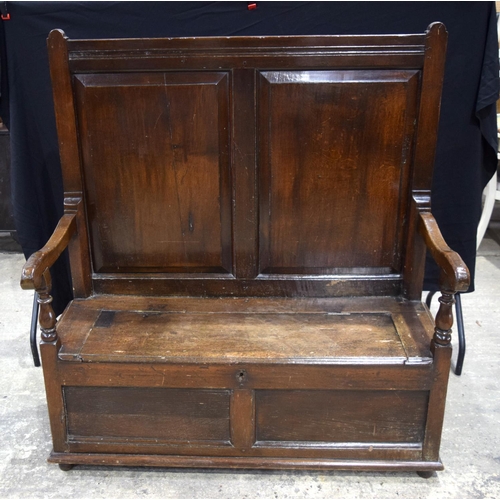 3490 - A large double panelled oak settle with blanket box 138 x 125 x 83 cm.