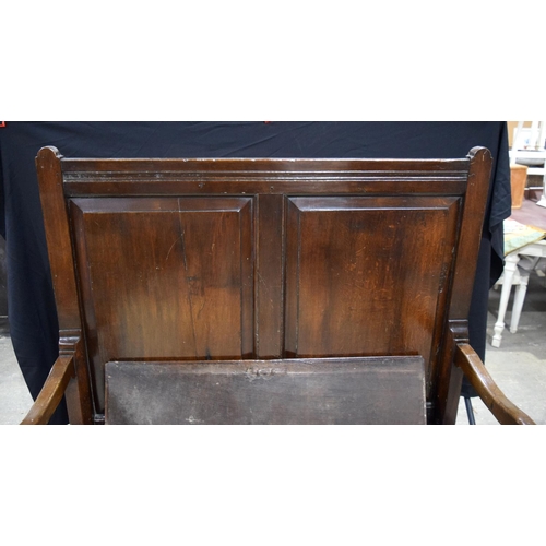 3490 - A large double panelled oak settle with blanket box 138 x 125 x 83 cm.